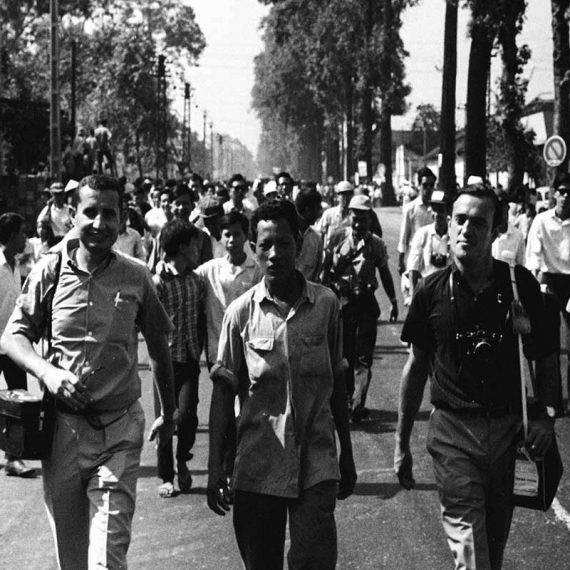 Arnett walks with other journalists covering Buddhist demonstration, Saigon, 1963