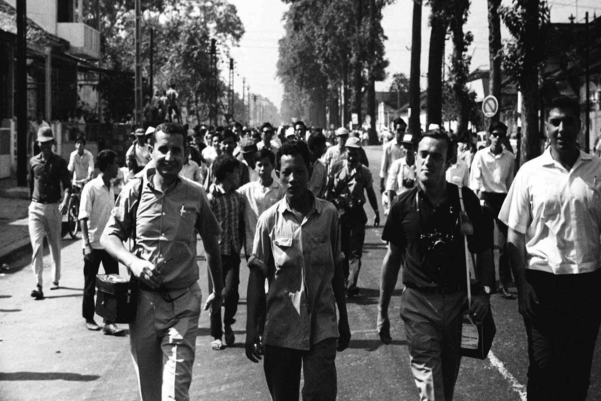 Arnett walks with other journalists covering Buddhist demonstration, Saigon, 1963