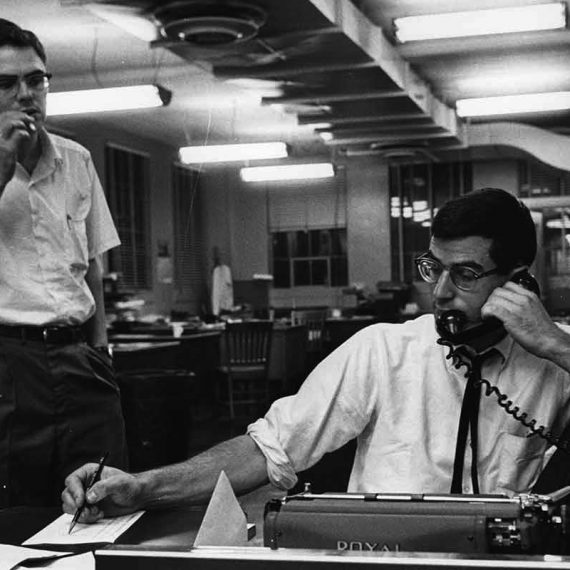 Halberstam works the phones at his New York Times desk, 1964
